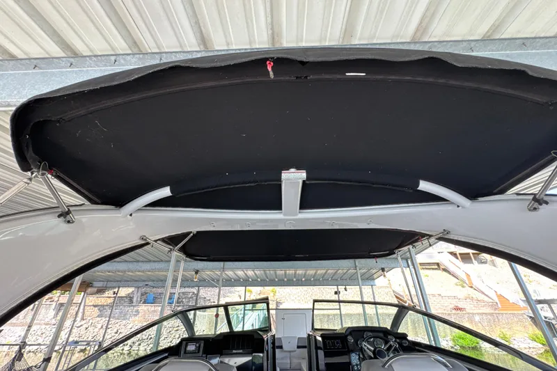 Slide: The Image of 2017 Four Winns H290 boat interior with black canopy and modern dashboard. - 49