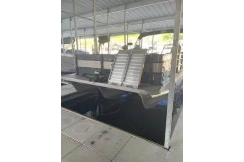 Slide: The Image of 2023 PlayCraft 27 Infinity boat docked under a covered marina. - 3