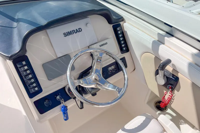 Slide: The Image of 2019 Robalo R247 Dual Console helm with Simrad display and steering wheel. - 10