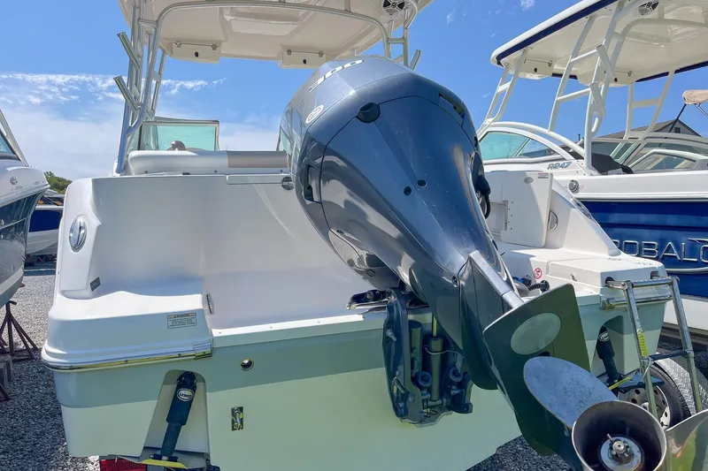 Slide: The Image of 2019 Robalo R247 Dual Console boat with powerful outboard motor, docked under clear skies. - 17