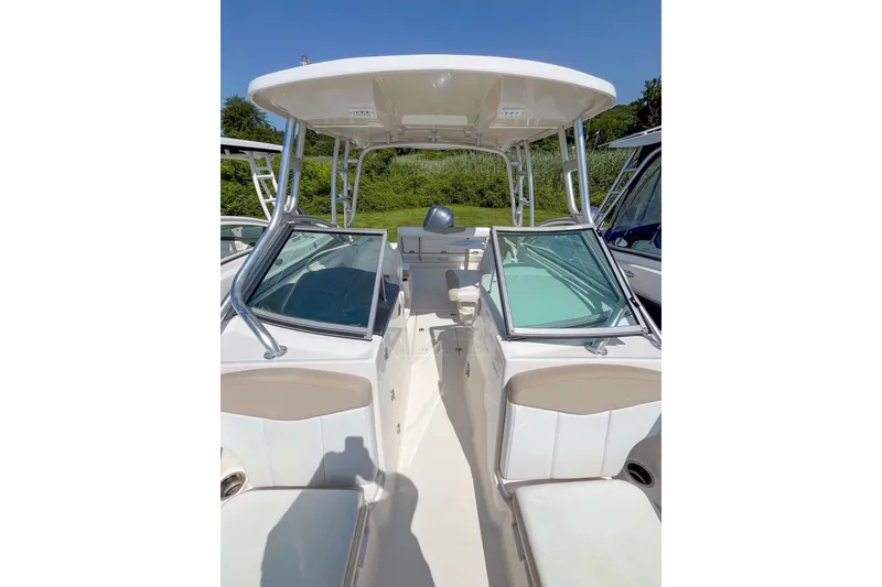Slide: The Image of 2019 Robalo R247 Dual Console boat with open deck and seating, under clear blue sky. - 15