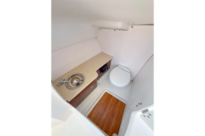 Slide: The Image of 2019 Robalo R247 Dual Console boat interior with sink and toilet. - 10