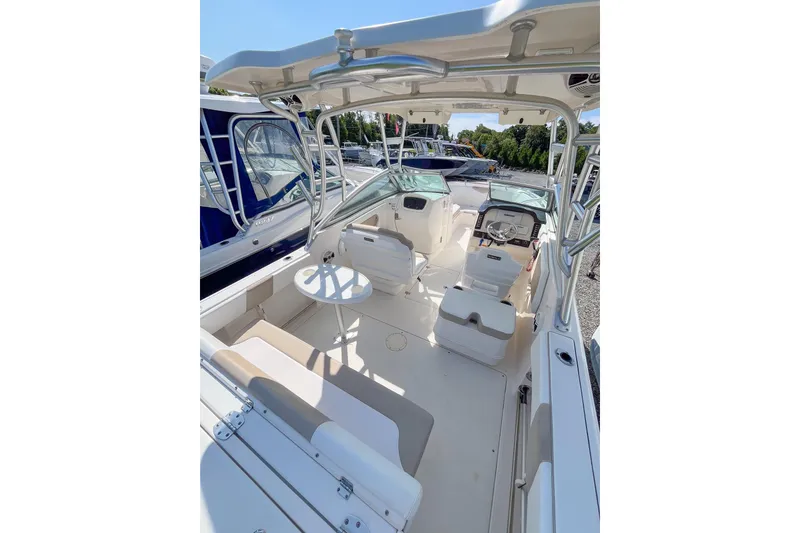 Slide: The Image of 2019 Robalo R247 Dual Console boat interior with seating and helm, docked outdoors. - 3
