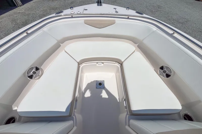 Slide: The Image of 2019 Robalo R247 Dual Console boat interior with white seating and speakers. - 11