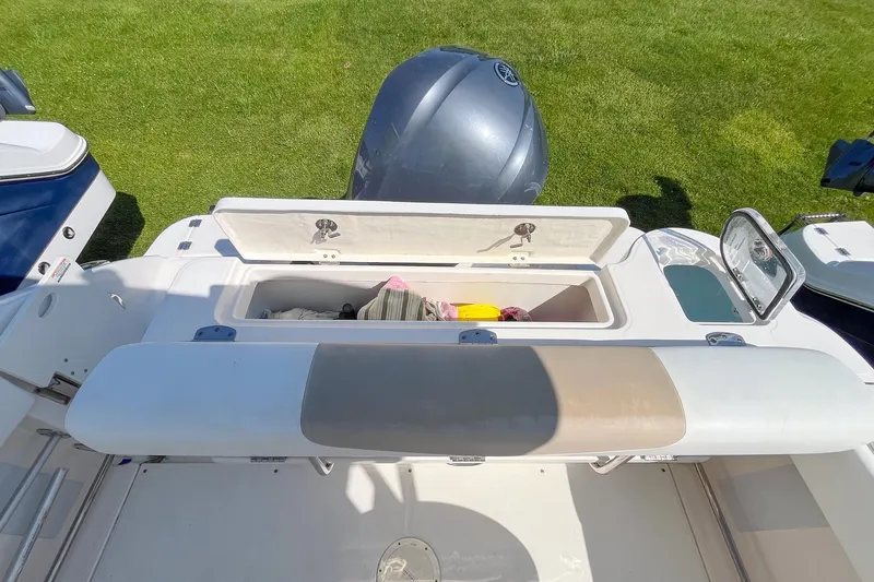 Slide: The Image of 2019 Robalo R247 Dual Console boat with open storage compartment and Yamaha engine. - 7