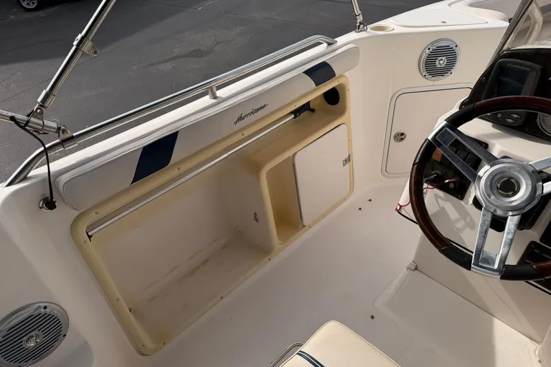Slide: The Image of 2006 Hurricane FunDeck GS 211 OB boat interior with steering wheel and storage compartment. - 13