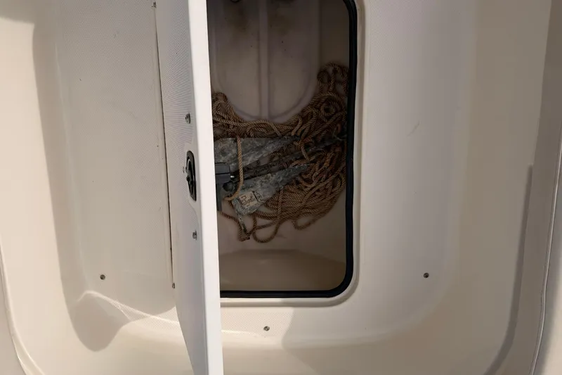 Slide: The Image of Open storage compartment on 2006 Hurricane FunDeck GS 211 OB with rope and anchor inside. - 18