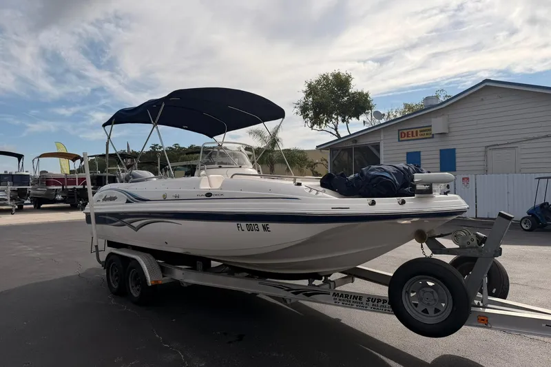 Slide: The Image of 2006 Hurricane FunDeck GS 211 OB boat on trailer, parked near a building. - 5