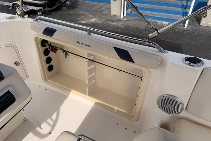 Slide: The Image of 2006 Hurricane FunDeck GS 211 OB boat interior with storage compartment and fishing rod holder. - 12