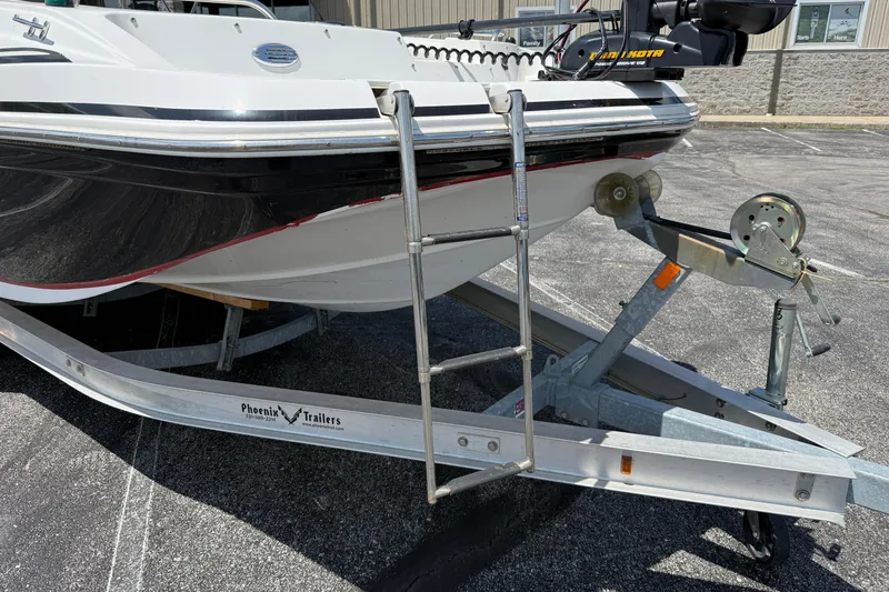 Slide: The Image of 2014 Hurricane SunDeck Sport 188 OB boat on trailer, featuring a ladder and winch. - 25