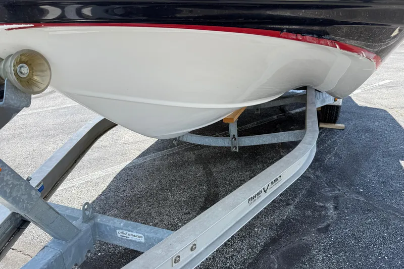Slide: The Image of 2014 Hurricane SunDeck Sport 188 OB boat on trailer, showing hull and trailer details. - 23
