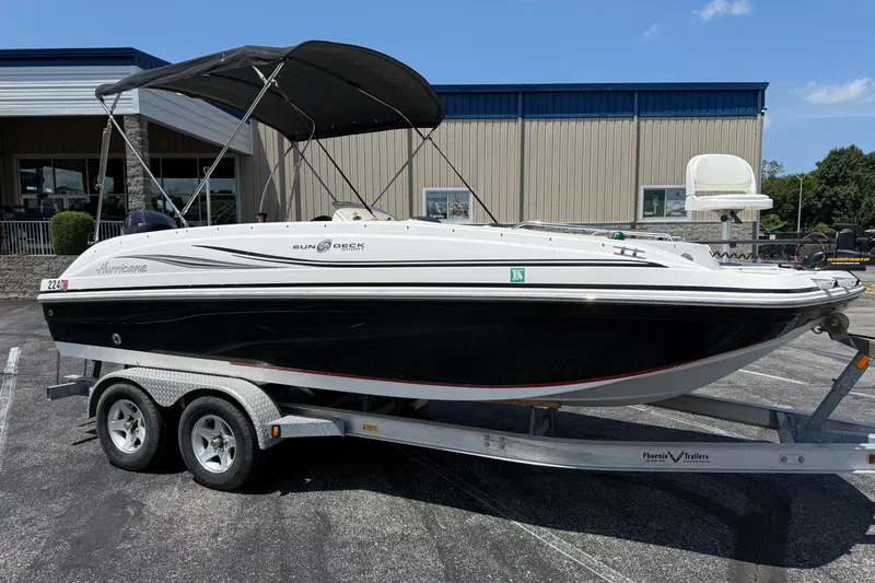 The Image of 2014 Hurricane SunDeck Sport 188 OB boat on trailer, parked outdoors. - 1
