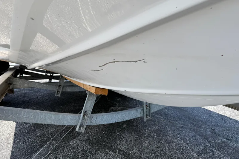 Slide: The Image of 2014 Hurricane SunDeck Sport 188 OB boat hull with visible scratch on trailer. - 24