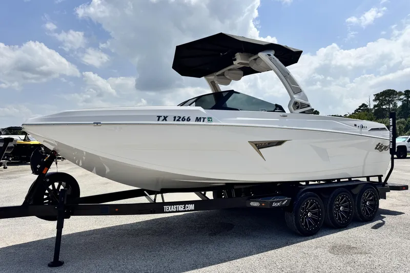 Slide: The Image of 2025 Tigé 24RZX boat on trailer under cloudy sky, side view. - 9