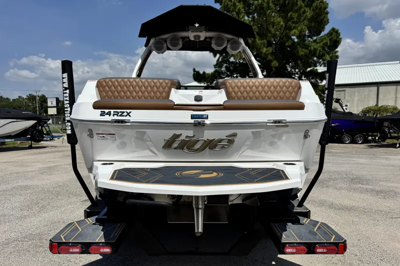 Slide: The Image of 2025 Tigé 24RZX boat rear view with brown seating and sleek design. - 7