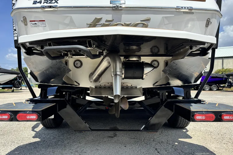 Slide: The Image of Rear view of 2025 Tigé 24RZX boat on trailer, showcasing propeller and exhaust system. - 6