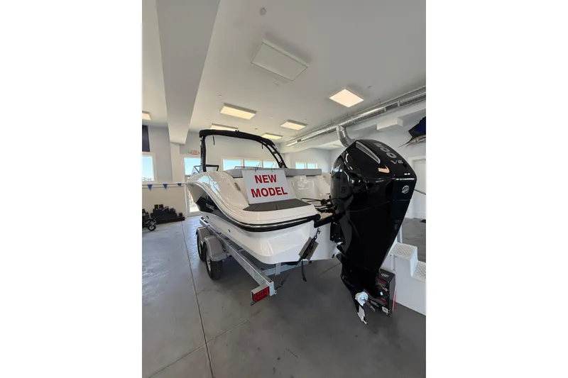 Slide: The Image of 2026 Bayliner V22 boat in showroom, featuring "New Model" sign and powerful outboard motor. - 10