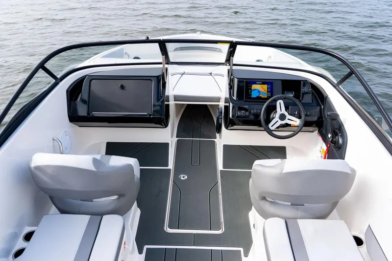 Slide: The Image of Manufacturer Provided Image: 2026 Bayliner V22 boat interior with modern dashboard and seating on water. - 11