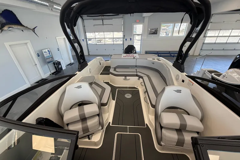 Slide: The Image of 2026 Bayliner V22 boat interior with sleek seating and modern design in showroom. - 8