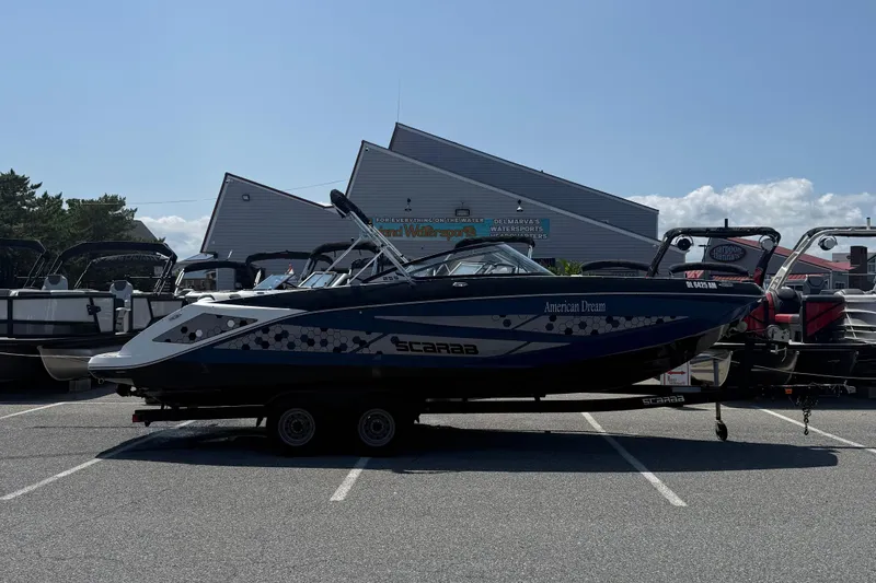 The Image of 2020 Scarab 255 Open ID boat on trailer in parking lot, side view. - 1