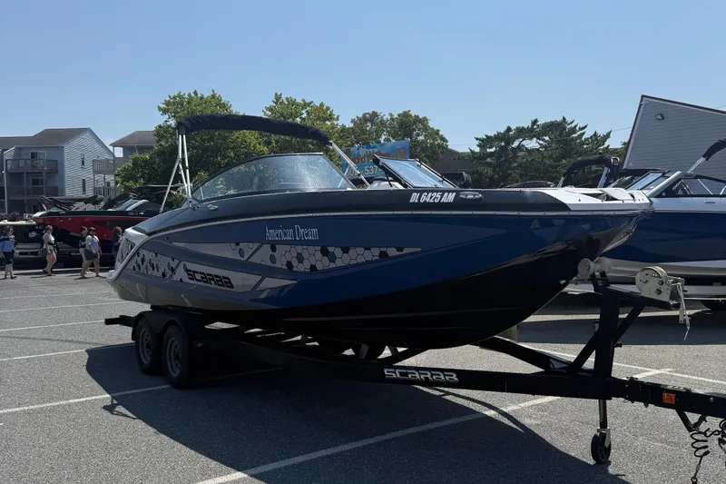 Slide: The Image of 2020 Scarab 255 Open ID boat on trailer in parking lot, labeled "American Dream." - 2
