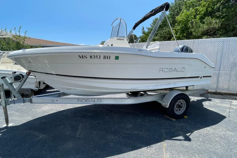 The Image of 2018 Robalo R180 Center Console boat on trailer, parked outdoors. - 1