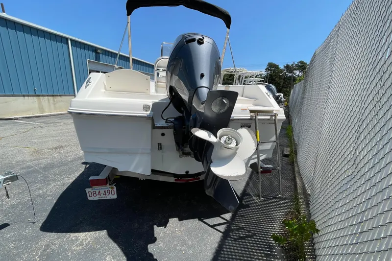 Slide: The Image of 2018 Robalo R180 Center Console boat with outboard motor, parked near a fence. - 15