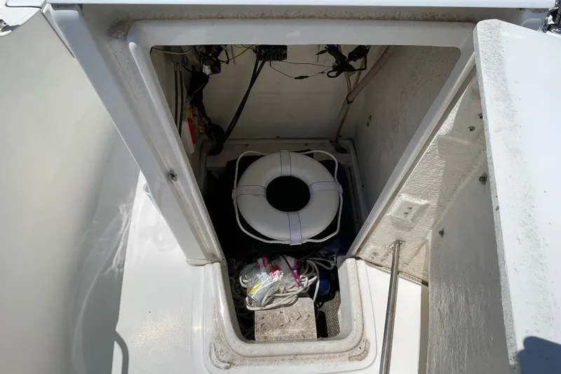 Slide: The Image of Storage compartment of 2018 Robalo R180 Center Console boat with life preserver and equipment. - 16