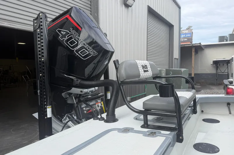 Slide: The Image of 2027 Skuta 24 Cat boat with Racing 400 engine, docked near a warehouse. - 11