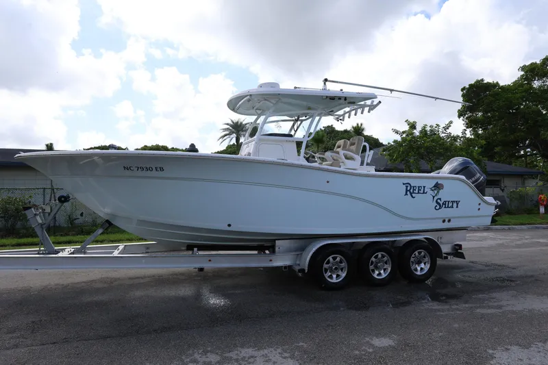 Slide: The Image of 2015 Sea Fox 286 Commander boat on trailer, labeled "Reel Salty," parked on a street. - 5