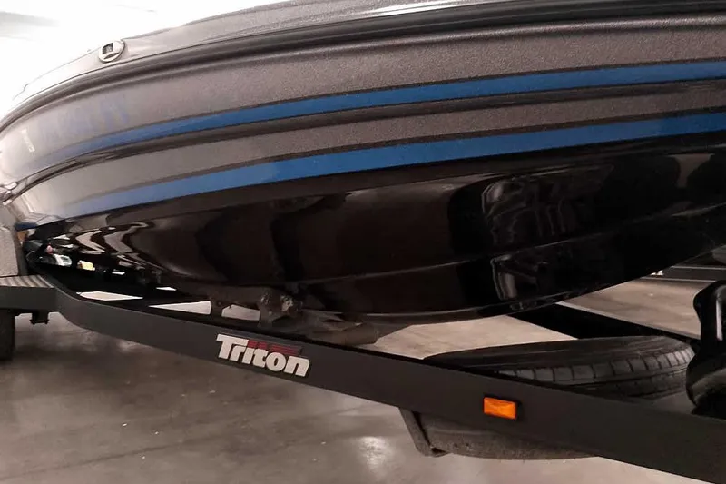 Slide: The Image of 2015 Triton 19 TrX boat on trailer, showcasing sleek hull design and branding. - 8