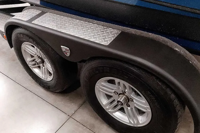 Slide: The Image of Trailer wheels of a 2015 Triton 19 TrX boat with diamond plate fender. - 14
