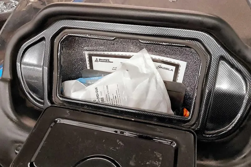 Slide: The Image of Storage compartment in a 2015 Triton 19 TrX boat, containing documents and items. - 26