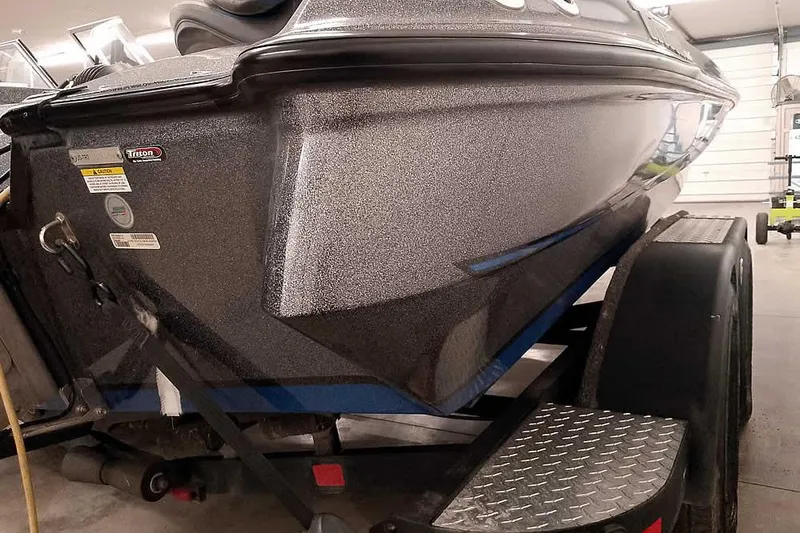Slide: The Image of 2015 Triton 19 TrX boat on trailer in garage, showcasing sleek hull design. - 16