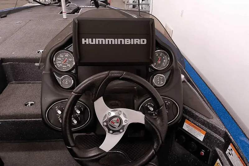 Slide: The Image of 2015 Triton 19 TrX boat dashboard with Humminbird display and steering wheel. - 29