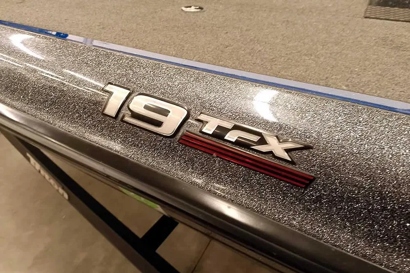 Slide: The Image of 2015 Triton 19 TrX boat with metallic finish and model emblem. - 5