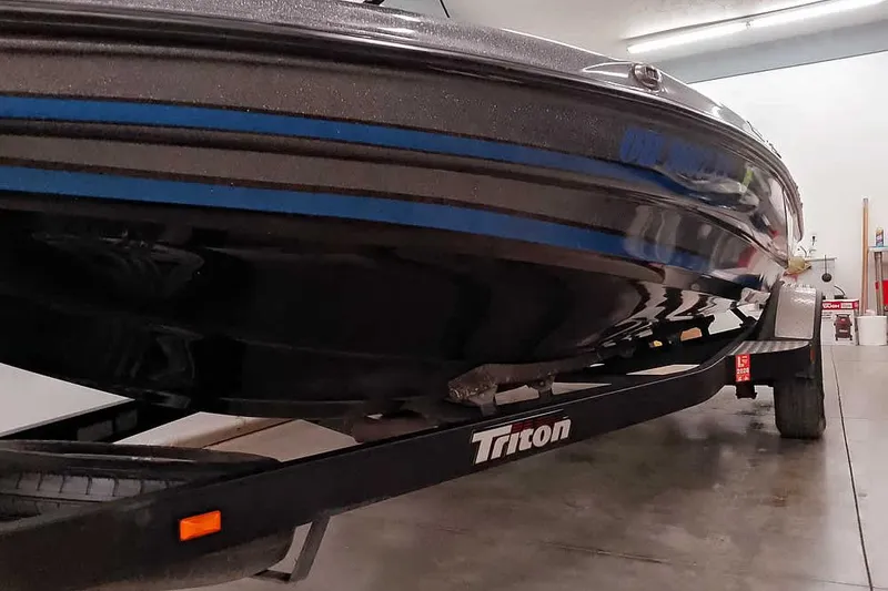 Slide: The Image of 2015 Triton 19 TrX boat on trailer in a garage setting. - 9
