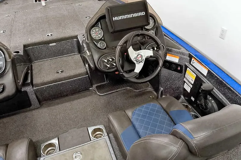 Slide: The Image of 2015 Triton 19 TrX boat interior with steering wheel, Humminbird display, and cushioned seating. - 28