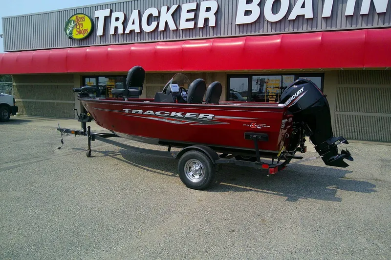 Slide: The Image of 2024 Tracker Pro Guide V-16 SC boat displayed outside Bass Pro Shops. - 2