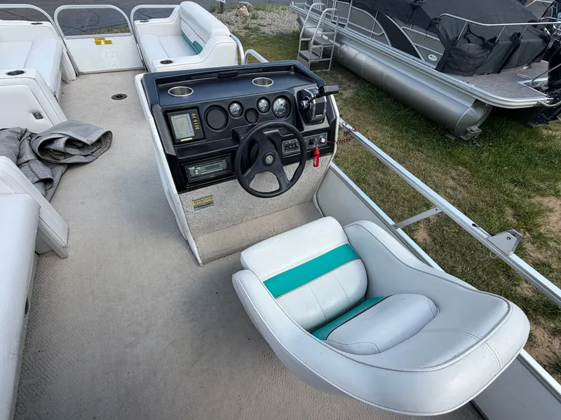 Slide: The Image of The image shows the cockpit of a 1994 Starcraft 240 Stardeck Pontoon with a white seat. - 6
