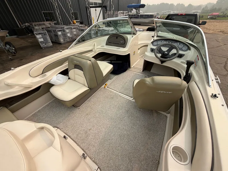 Slide: The Image of The image shows the cockpit of a 2005 Sea Ray 185 Sport boat with beige seats and a helm. - 4