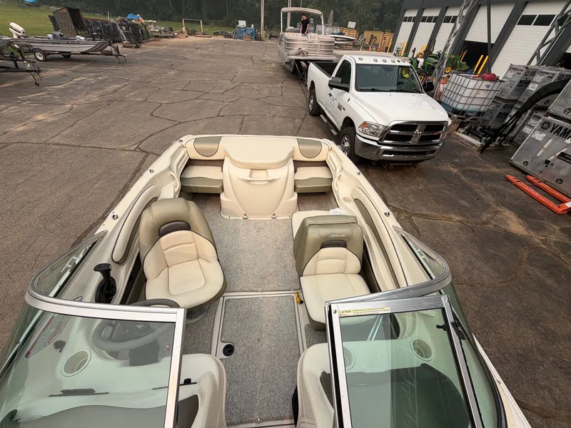 Slide: The Image of A 2005 Sea Ray 185 Sport on a lot. It features beige seating and an open cockpit. - 2