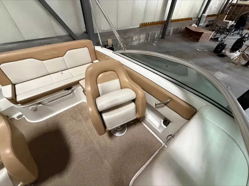 Slide: The Image of The image shows the interior of a 2011 Sea Ray 220 Sundeck boat with beige and white seating. - 6