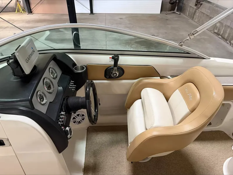 Slide: The Image of The image shows the cockpit of a 2011 Sea Ray 220 Sundeck boat with a beige seat. - 8