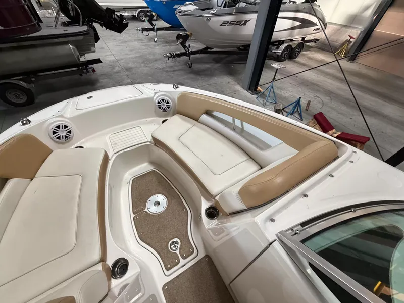 Slide: The Image of The image shows the bow area of a Sea Ray 220 Sundeck boat with beige upholstery. - 10