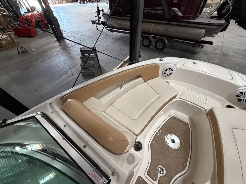Slide: The Image of The image shows the bow area of a 2011 Sea Ray 220 Sundeck boat with beige upholstery. - 11