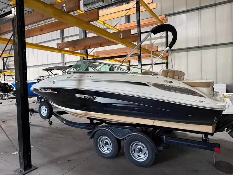 Slide: The Image of A 2011 Sea Ray 220 Sundeck on a trailer in a warehouse setting. - 2