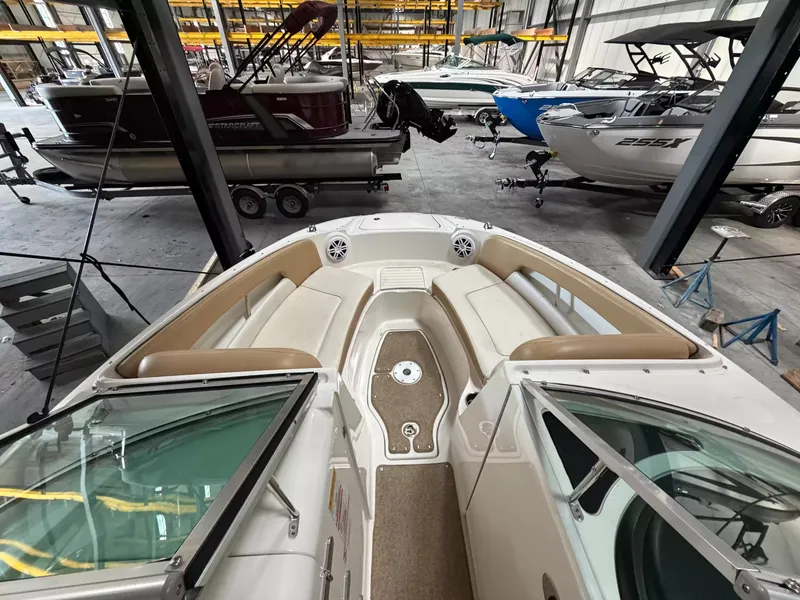 Slide: The Image of The image shows the bow area of a 2011 Sea Ray 220 Sundeck boat in a storage facility. - 9