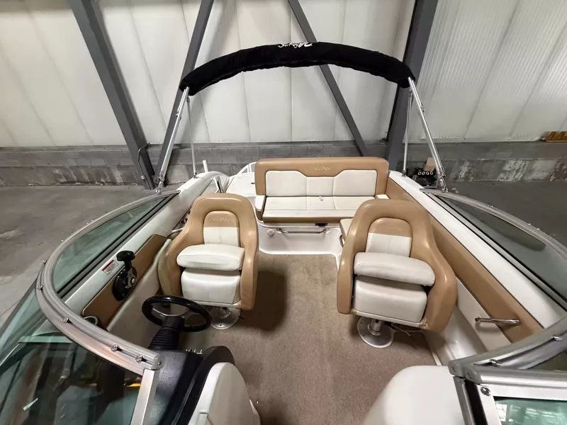 Slide: The Image of The image shows the cockpit of a 2011 Sea Ray 220 Sundeck boat with beige seating. - 5