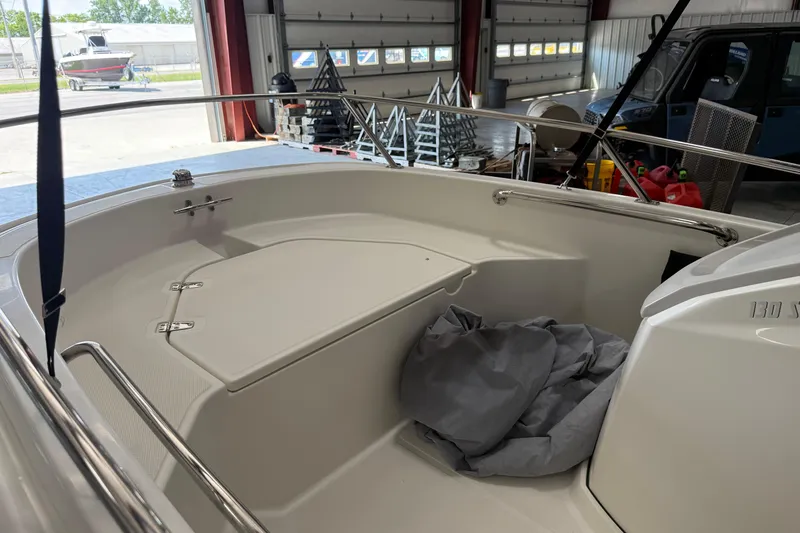Slide: The Image of 2021 Boston Whaler 130 Super Sport boat interior in a garage setting. - 7